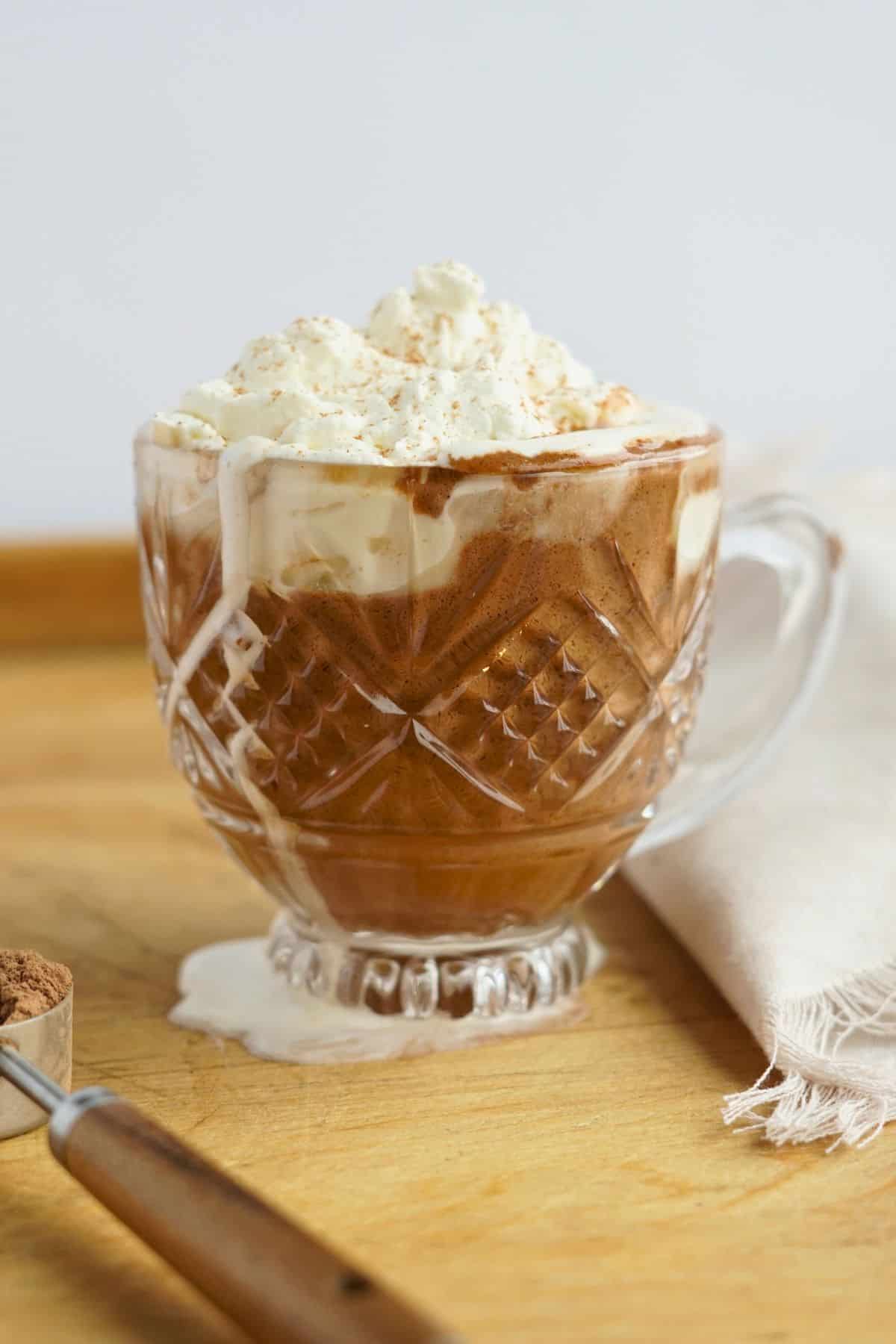 bone broth hot chocolate in glass mug on cutting board