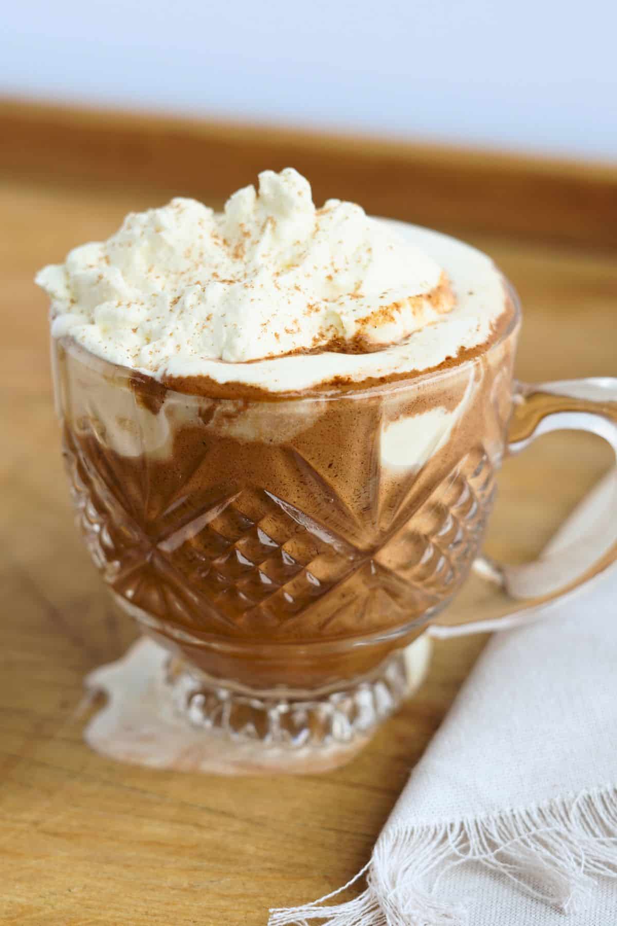 bone broth hot chocolate in glass mug on cutting board