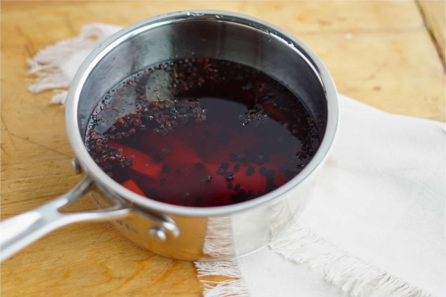Elderberries and ginger infusing in water in a pot