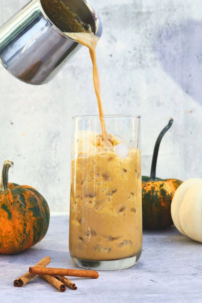 Bone broth pumpkin spice latte pouring into glass with ice